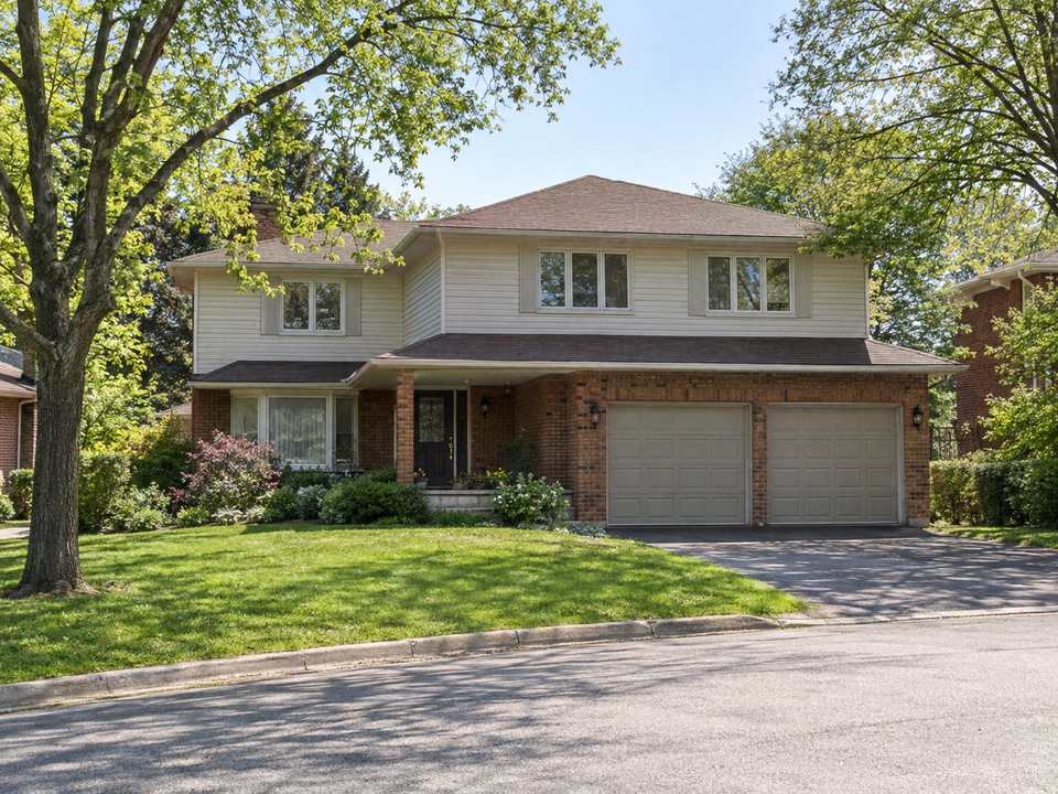 A 1980s two-storey detached house with a double garage on a curving street in Erin Mills